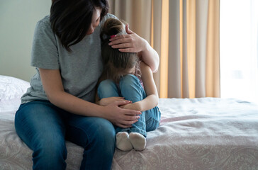 Loving young mother touching upset little daughter, expressing support, young mum comforting...