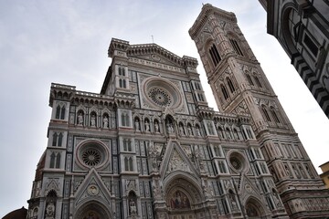 イタリアのフィレンツェを象徴するサンタ・マリア・デル・フィオーレ大聖堂の壮麗なファサード 白と緑とピンクの大理石で装飾されたルネサンス建築の傑作を捉えた風景写真 歴史と芸術の都トスカーナの観光名所イメージ