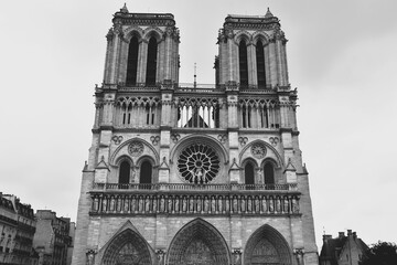 フランスのパリにある世界遺産ノートルダム大聖堂の正面を捉えたモノクロ写真 歴史的なゴシック建築の美しさと荘厳な雰囲気を表現したアートな一枚 緻密な彫刻やファサードのディテールが際立つ白黒の風景素材