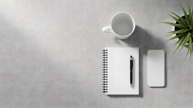 Overhead view of a minimalist workspace with a notebook, pen, mobile phone, coffee cup, and plant on a gray surface.