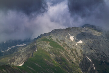 Beautiful alpine scenery, pristine glacier lake, rocks and spring flowers in the Transylvanian Alps in  early summer
