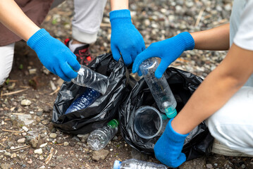 Volunteers wearing aprons and gloves in a cleanup activity. Holding trash bags filled with garbage. Protecting the environment by cleaning up litter