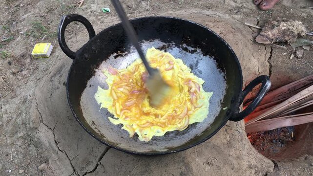 Traditional Outdoor Egg Cooking in Iron Kadhai over Wood Fire, Stir Frying Eggs in Rustic Village Kitchen, Rural Indian Cooking, 4K Stock Footage