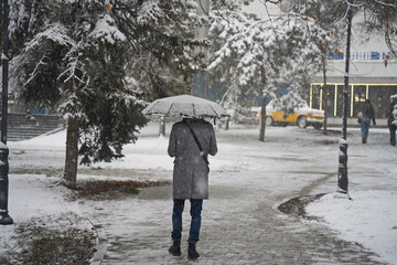 Almaty, Kazakhstan - 12.18.2025 : People are walking down the street in a heavy snowfall.