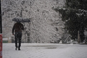 Almaty, Kazakhstan - 12.18.2025 : People are walking down the street in a heavy snowfall.