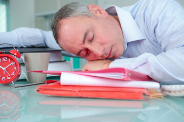 Obraz premium exhausted businessman sleeping on the table