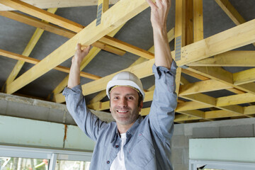 portrait of workman fitting wooden truss