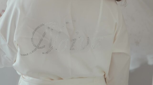 Close view of white bridal robe with Noiva lettering detail