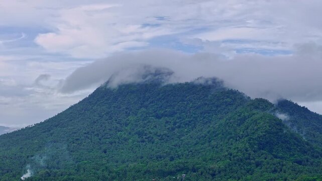 Aerial footage of Mt Paco in Surigao del Norte, Philippines, showing cloud-covered mountain terrain and forested slopes. Drone footage captures natural landscape details under overcast conditions.