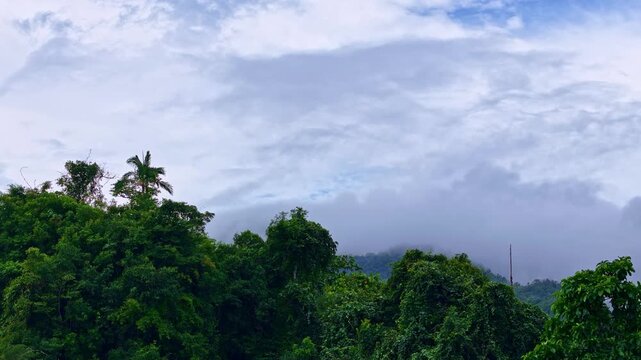 Aerial reveal of Mount Paco covered in low clouds, showing forested slopes and mountainous terrain in the Philippines. Drone footage highlights natural landscape, elevation, and atmospheric conditions