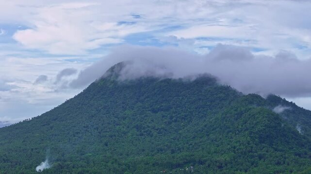 Aerial drone footage of Mt Paco in Surigao del Norte, Philippines, showing cloud-shrouded mountain terrain and forested slopes. Natural landscape captured from above under overcast conditions.