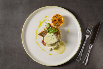 Grilled sea bream fillet with creamy sauce and elegant plating