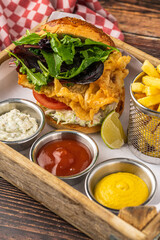 Crispy fried chicken burger served with fries and creamy dips