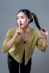 Asian Woman Making Shush Gesture While Holding Ponytail