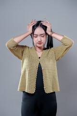 Indonesian Woman Holding Head in Frustrated Expression