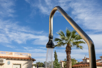Outdoor shower with running water against blue sky