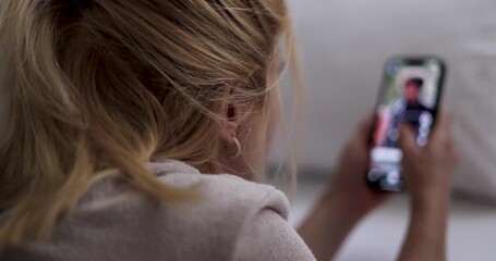 Woman doom scrolling through social media or watching reels. Alone in bedroom, staring at smartphone. emotional distance psychological strain. Smartphone addiction. Digital overload, loneliness.