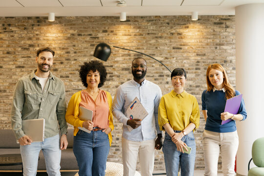 Business team standing in a modern office, showcasing teamwork and creativity