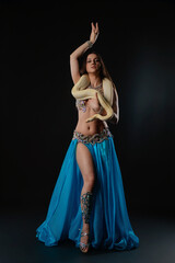 Woman performs dance with snake in studio setting during evening event