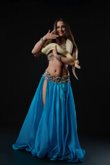 Woman dances with snake in a studio at night during a performance