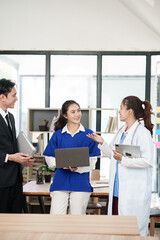 A lone Asian male doctor is working in a hospital conference room.