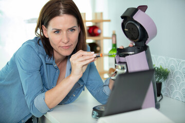 woman repairs a coffee machine