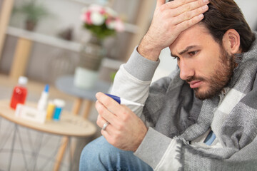 poorly man at home is worried about his high temperature