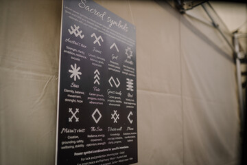 Riga, Latvia - December 19, 2025: Sacred symbols chart displayed on a wall, showcasing various spiritual meanings and designs for guidance and inspiration