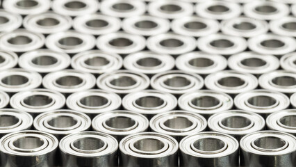 Rows of miniature ball bearings form a repeating pattern, symbolizing precision engineering, mass production, mechanical reliability, and modern industrial manufacturing background.