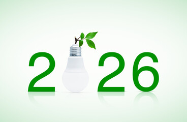 2026 text and LED light bulb with fresh green tree leaves, Happy new year 2026 ecology and saving energy concept
