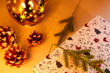 Christmas gift, pine cones, and a star-patterned lamp creating a festive holiday scene