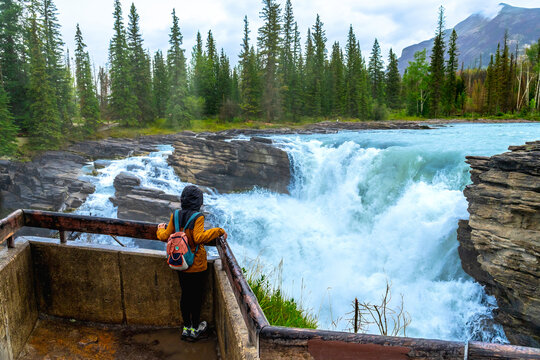 Tourist admiring athabasca falls in jasper national park, canada