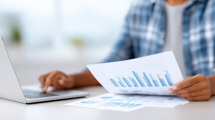 African American accountant analyzing financial reports with graphs and charts, working on a laptop at a bright office desk, showcasing professional financial analysis and productivity