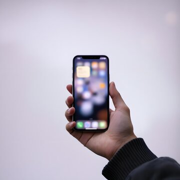 A person holding a smart mobile phone with a blank touch screen display represents modern wireless communication technology and business gadget connectivity