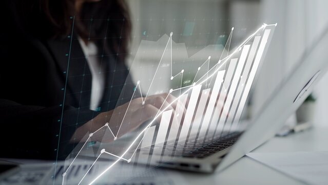 A business professional analyzes financial data and market trends using a laptop in a modern office. The image features digital overlays of graphs and charts, symbolizing growth. Copula - Powered by Adobe