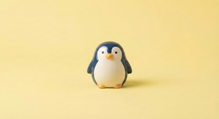 Cute Penguin Figurine on a Solid Yellow Background