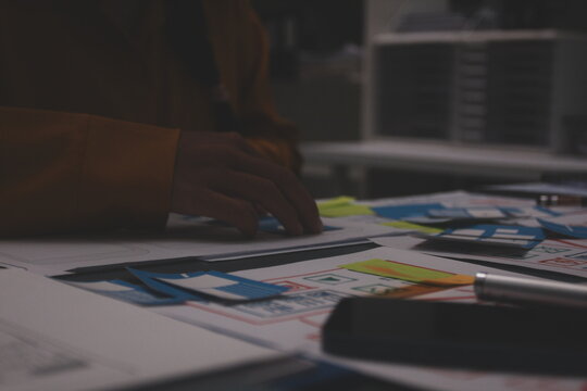 Team of uxui designers pointing at computer screen, discussing new mobile app design in the office - Powered by Adobe