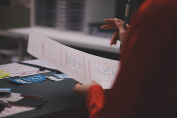 Team of uxui designers pointing at computer screen, discussing new mobile app design in the office