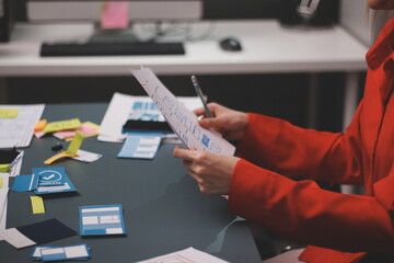 Team of uxui designers pointing at computer screen, discussing new mobile app design in the office