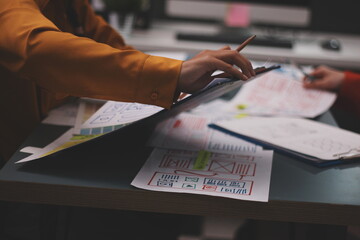 Team of uxui designers pointing at computer screen, discussing new mobile app design in the office