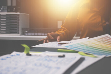 Team of uxui designers pointing at computer screen, discussing new mobile app design in the office