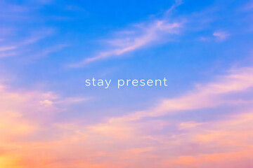 Horizontal Stay Present quote over soft pastel sky gradient with calm blue and peach tones, minimalist inspirational illustration for mindfulness practice, meditation content, wellness branding