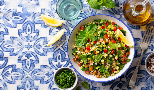 Warm bulgur salad with mint. Azulejo background. Copy space. Top view.