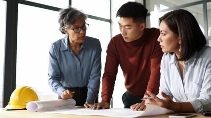 Three diverse architects collaborating over blueprints in office. Teamwork, Architecture, Business, Construction, Blueprints, Office, Collaboration