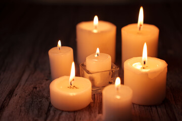 a collection of softly glowing candles on a wooden surface creates a warm and peaceful atmosphere, emphasizing tranquility and introspection in the gentle flickering light, glimmer, arrangement