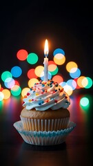 A birthday cupcake with a single flickering candle and colorful lights