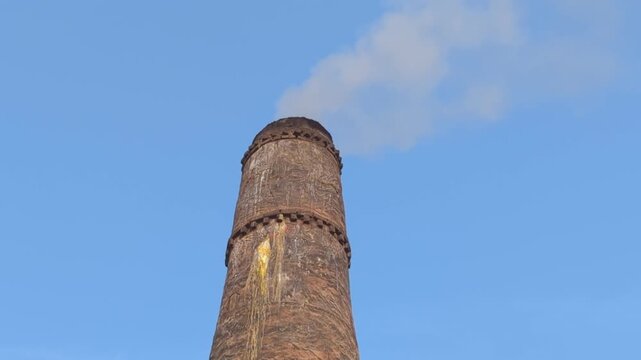 The white smoke is coming out from the chimney with blue sky background, Air pollution by brick kiln chimney, Ancient architecture of Uzbekistan, Registan square, Bibi khanym mosque, Itchan kala old