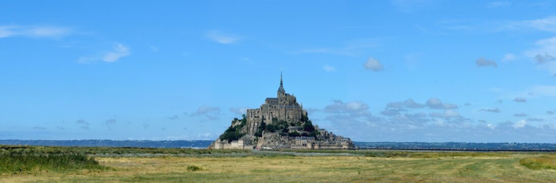 Panor&aacute;mica del Monte Saint-Michel visto desde lejos, tras campos de cultivo verdes, en Normand&iacute;a, Francia.
