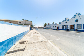 Colorful colonial buildings in Lüderitz, a small coastal town in Namibia, facing the Atlantic Ocean. Historic German architecture contrasts with desert landscapes, harbor views. © coffeinlix 