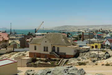 Colorful colonial buildings in Lüderitz, a small coastal town in Namibia, facing the Atlantic Ocean. Historic German architecture contrasts with desert landscapes, harbor views. © coffeinlix 